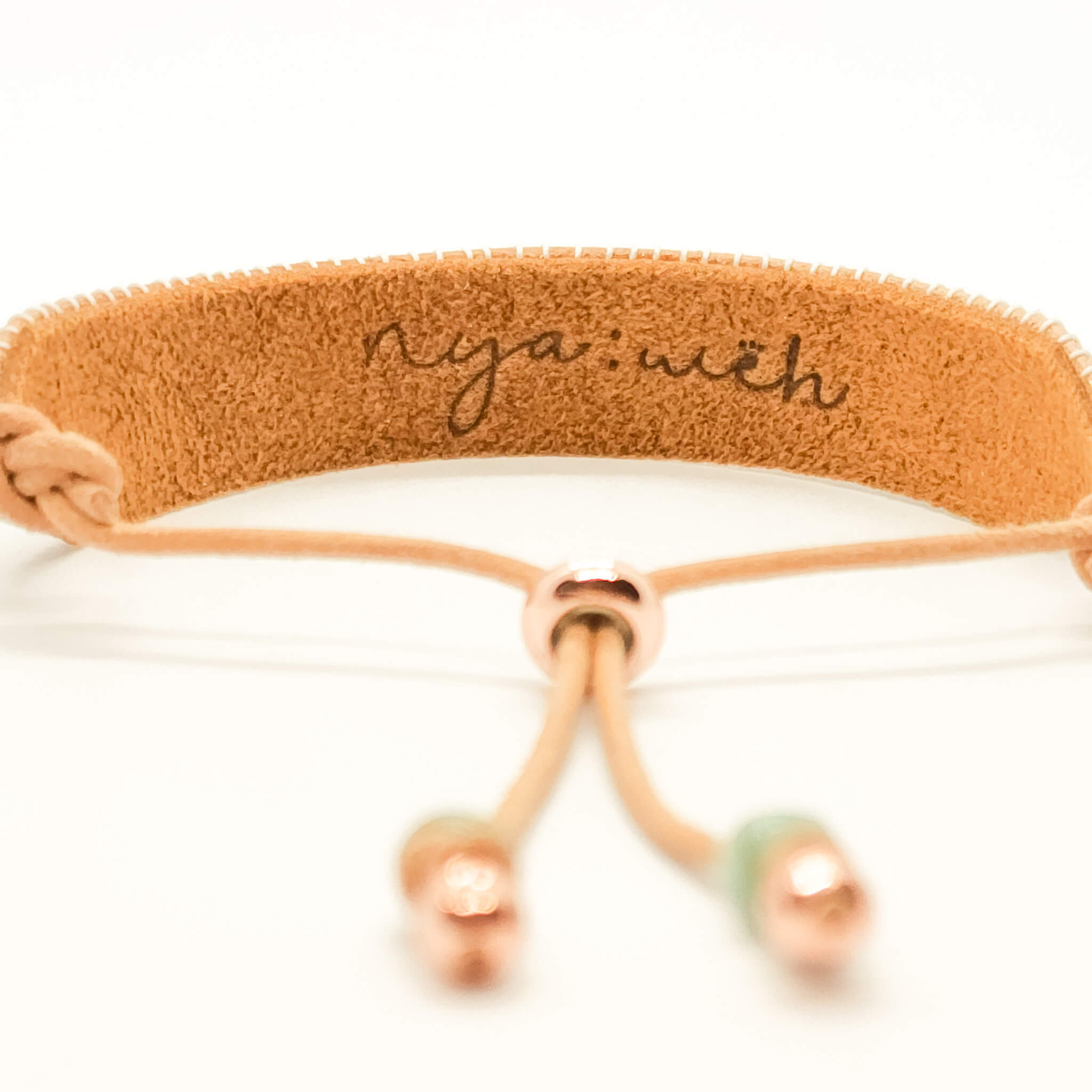 bracelet back view showing leather stamped nyaweh logo